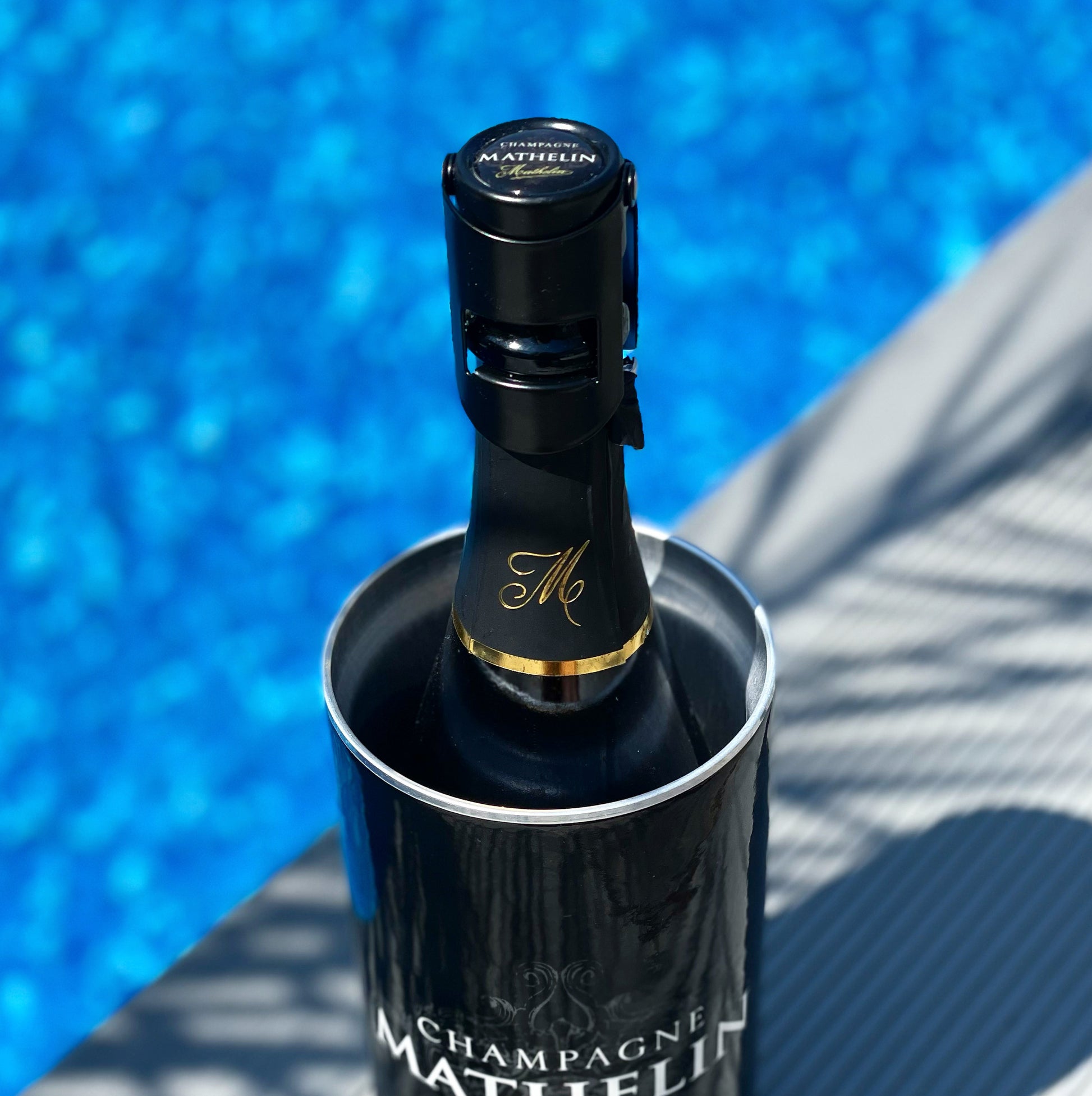 Champagneförslutare i svart metall på champagneflaska vid pool