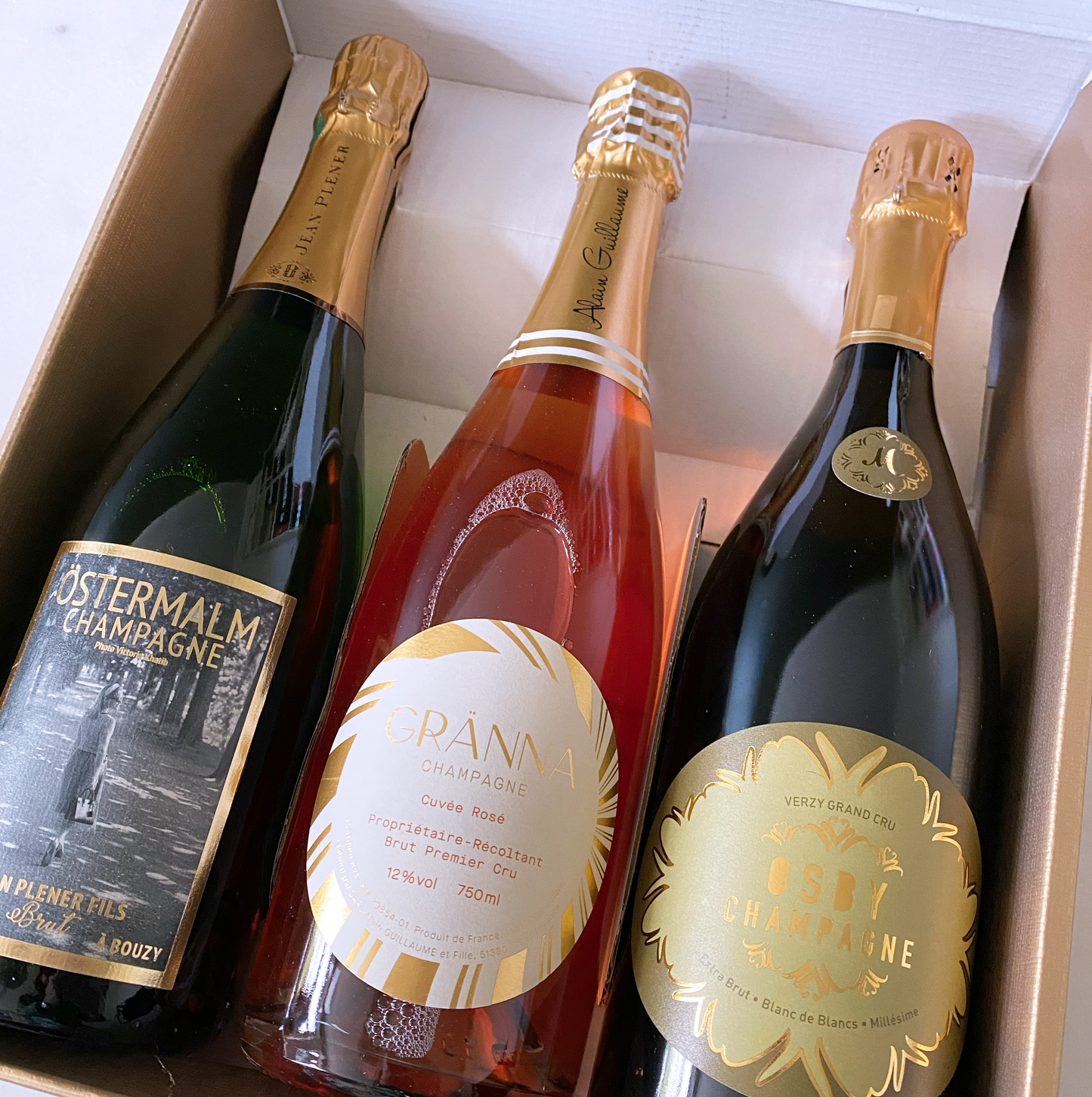 Elegant presentlåda i guld med plats för 3 champagneflaskor – linnepräglad kartong med avdelare. Närbild